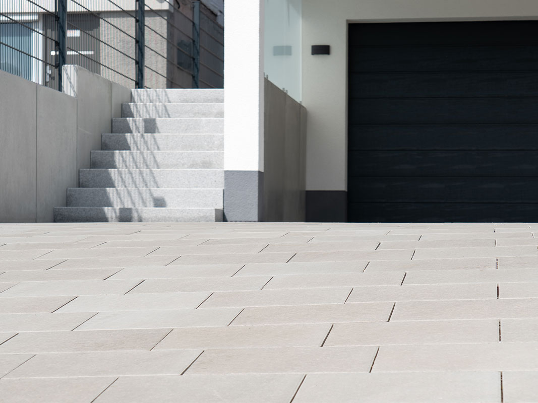 Schwarze Garage der Familie Grimm mit angrenzender Betontreppe links