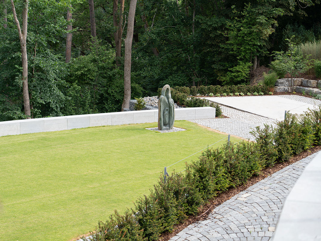 Vogelperspektive auf den Garten der Nussbaum GmbH mit zentraler Skulptur.
