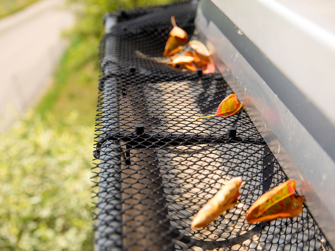 Nahaufnahme eines Laubschutzgitters, das an einem Dach installiert ist.