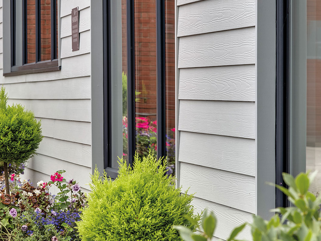 Detailaufnahme einer grauen Holzfassade an einem modernen Haus.
