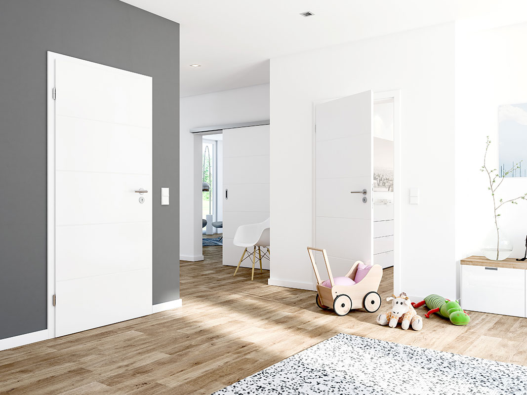 Wohnzimmerbereich mit Zugang zu drei Räumen: zwei mit herkömmlichen Türen, einer mit Schiebetür; im Vordergrund ein Holzpuppenwagen sowie Plüschtiere (Giraffe und Krokodil).