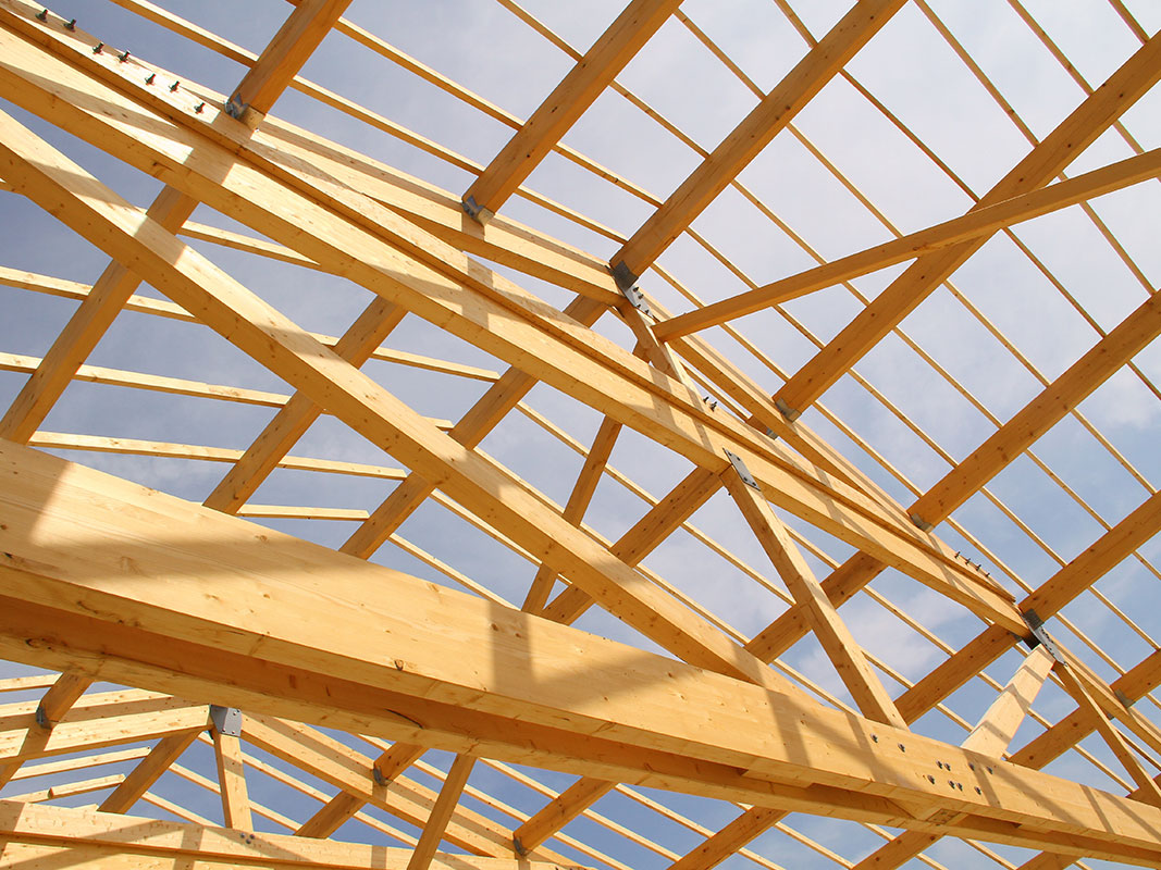 Konstruktiver Holzbau: Dachkonstruktion aus tragendem Bauholz, Detailansicht der Balken und Verbindungselemente.