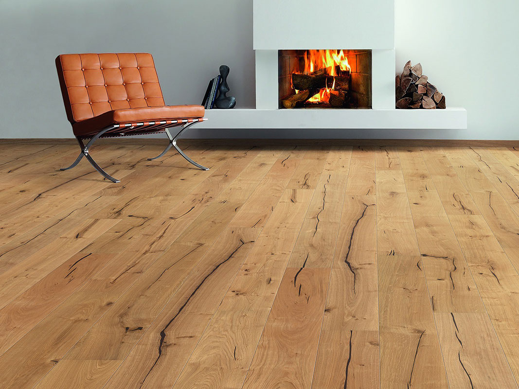 Wohnzimmer mit Parkettboden in auffälliger Maserung, modernem Designerstuhl und einem Ofen mit brennendem Feuer