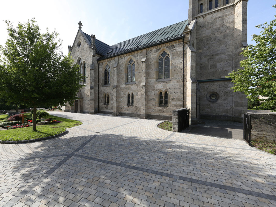 Großer Platz aus Klinker- und Ziegelpflastersteinen mit einer imposanten Stein-Kirche im Hintergrund.