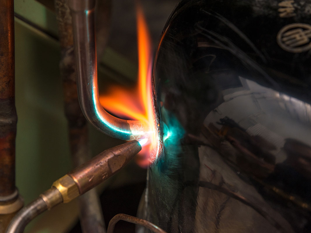 Schweißgerät mit roter Flamme beim Schweißen eines Metallblechs