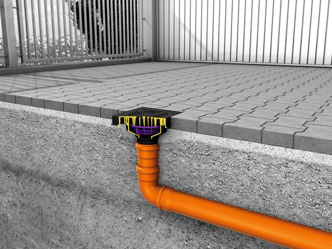 Seitenschnitt eines in Pflastersteinauffahrt integrierten Ablaufrohrs für Entwässerungssysteme.