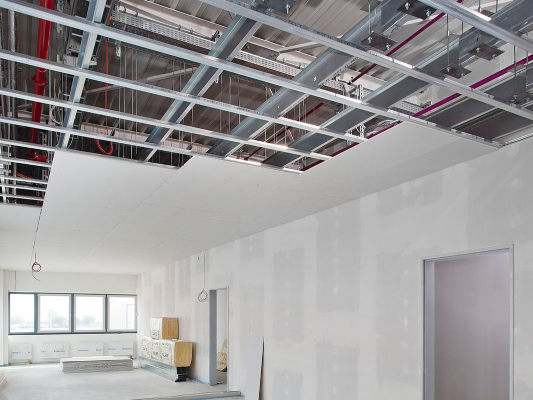 Neu gebauter Raum mit abgehängter Decke, die nur zur Hälfte installiert ist – Beispiel für Trockenbau-Lösungen