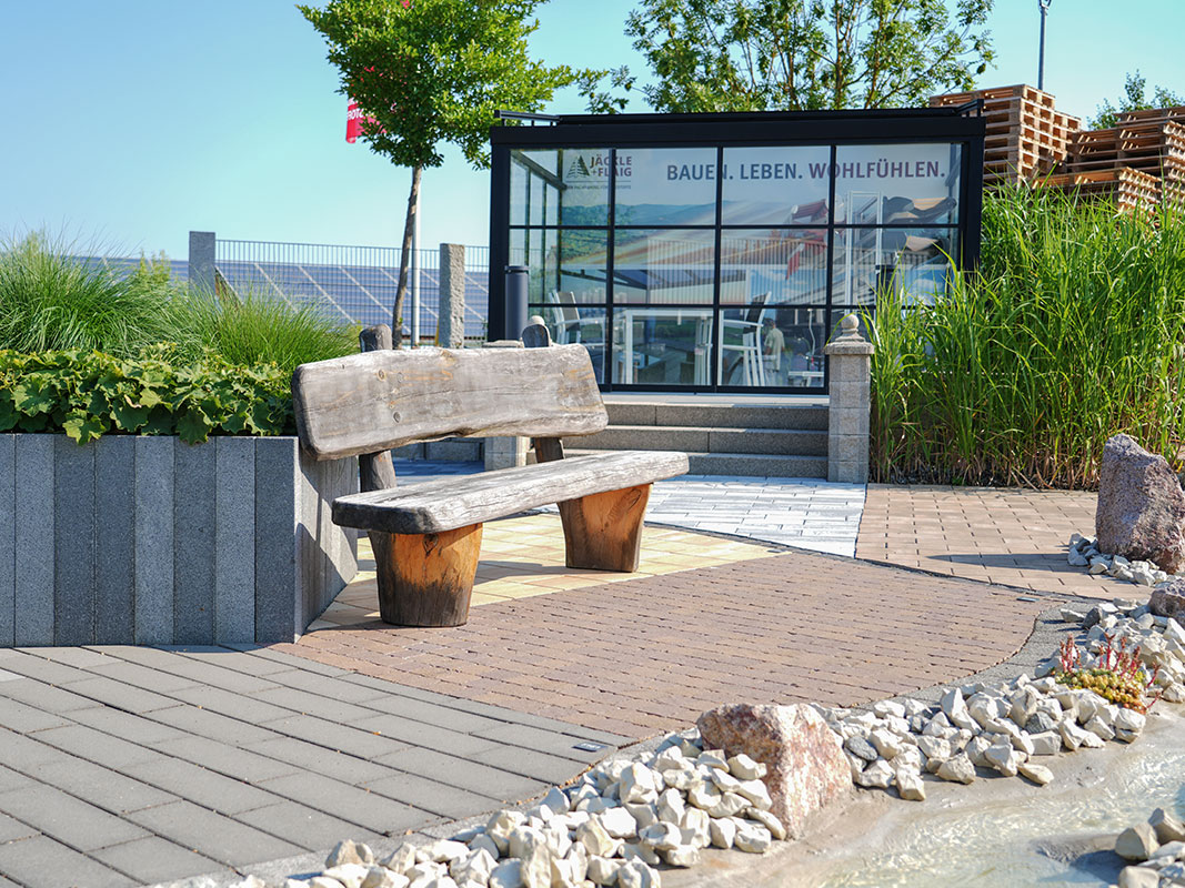 Steingartenausstellung in Niedereschach mit Holzbank vor Ausstellungspavillon.