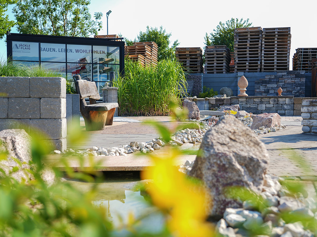 Steingartenausstellung in Niedereschach mit Pavillon, hohen Gräsern, Steinmauern, Bachlauf und Terrakotta-Gartenskulpturen