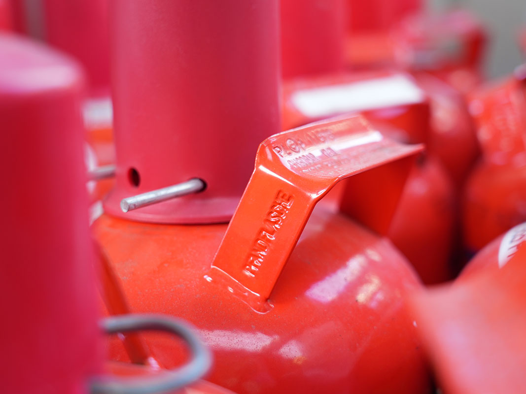 Rote Propangasflaschen in Nahaufnahme, stehend nebeneinander.